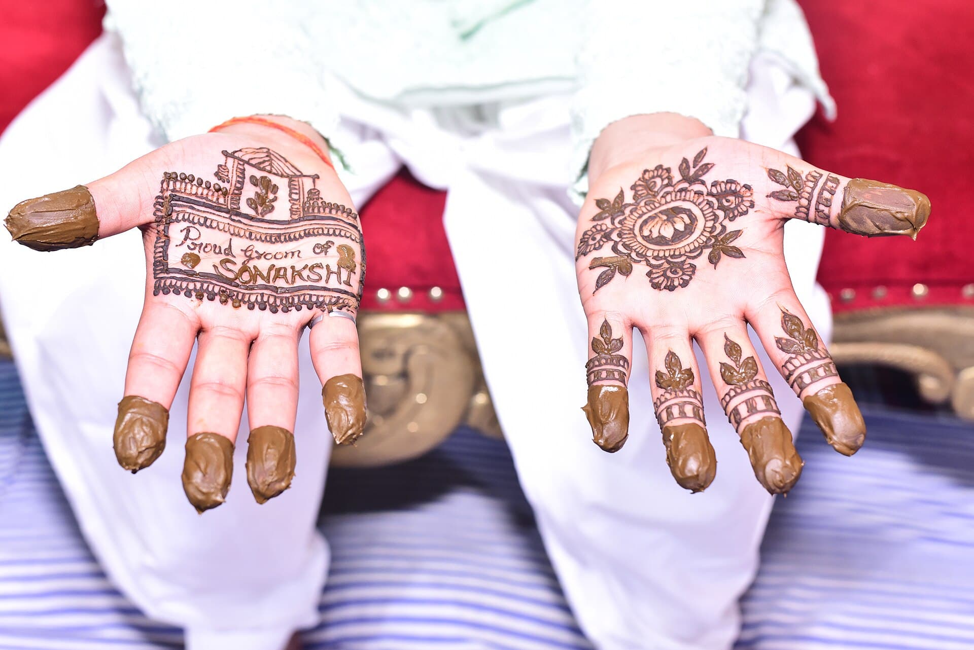 Close view of mehndi being applied to the bride's second hand.